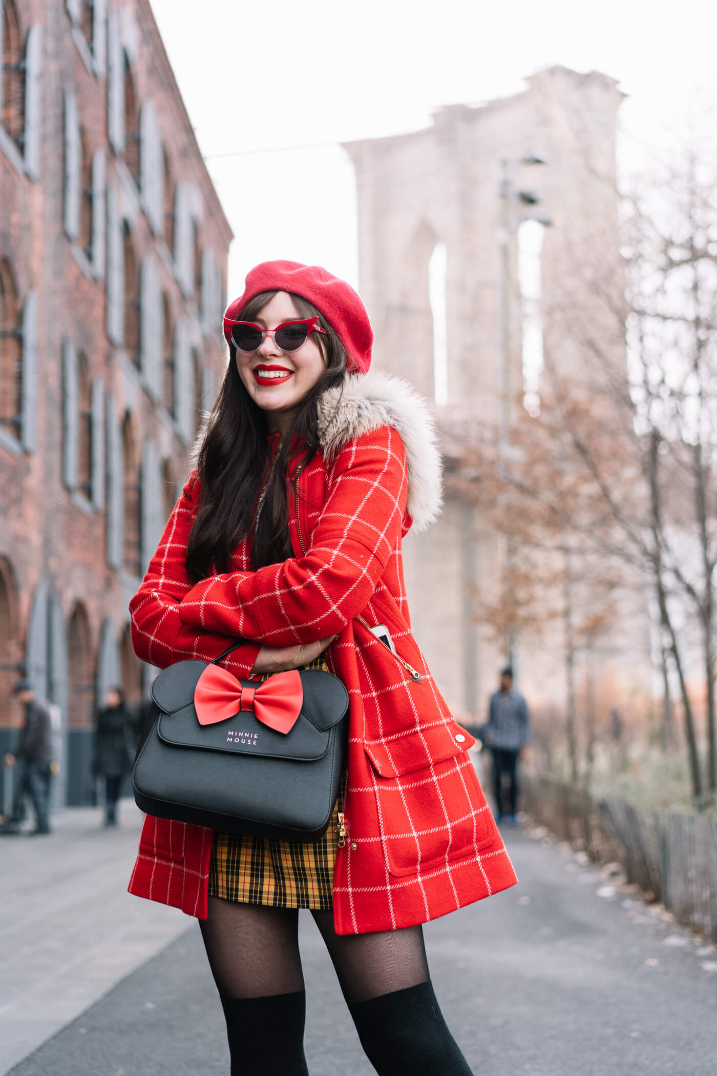 Evelyn Bourdon wearing a red checkered parka, vintage yellow plaid dress, red beret, minnie mouse bag, betty and veronica sunglasses, and black suede strappy block heels