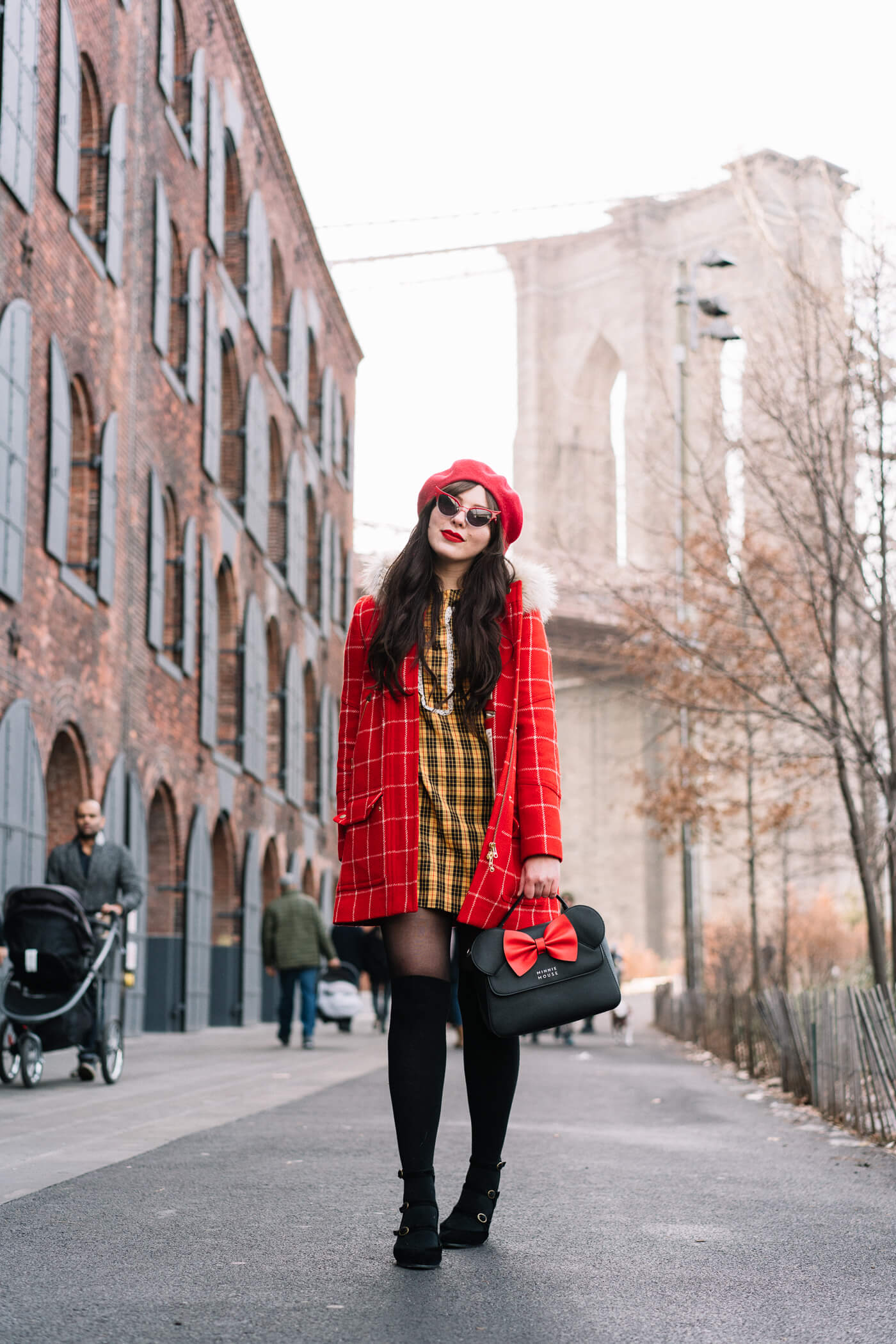 Evelyn Bourdon wearing a red checkered parka, vintage yellow plaid dress, red beret, minnie mouse bag, betty and veronica sunglasses, and black suede strappy block heels