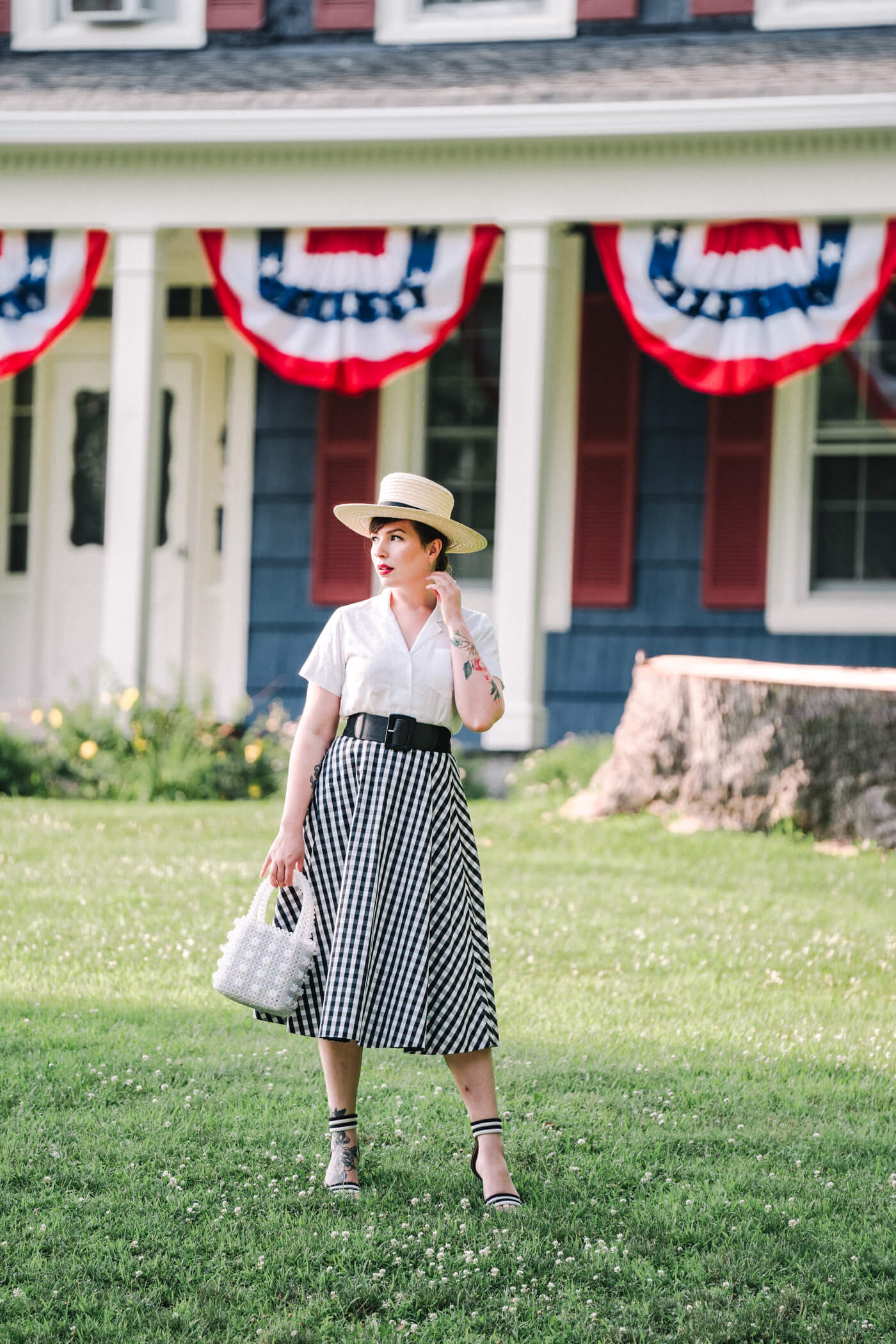 American girl wearing white top and black and white skirt