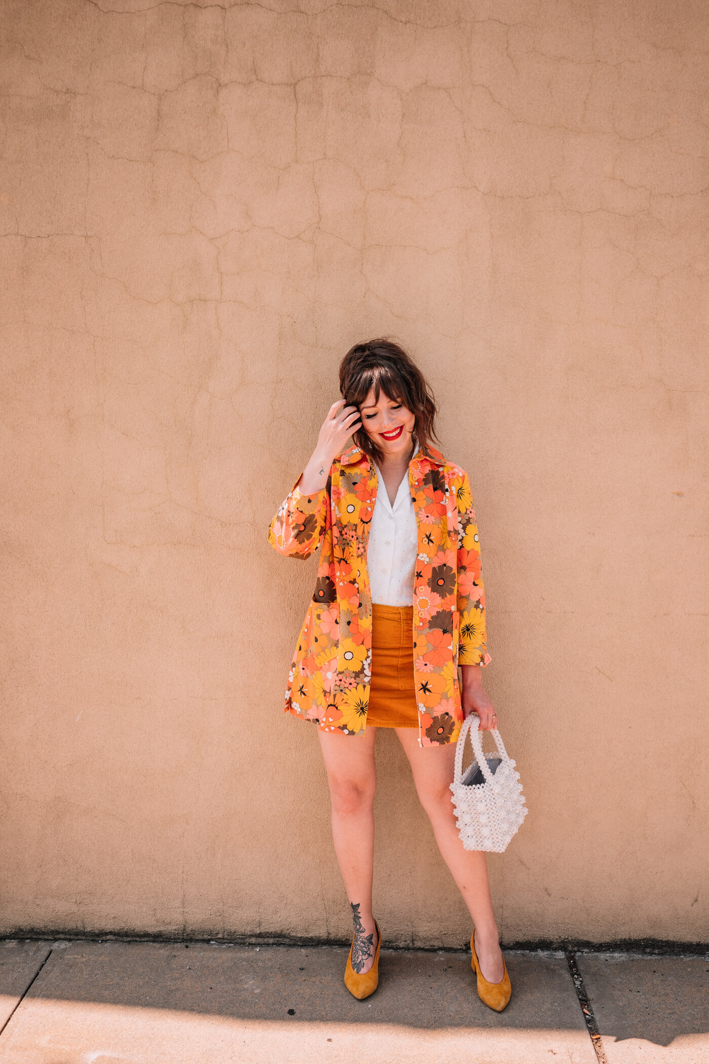 woman wearing white One Shirt 30 Ways, yellow skirt, and floral blazer 