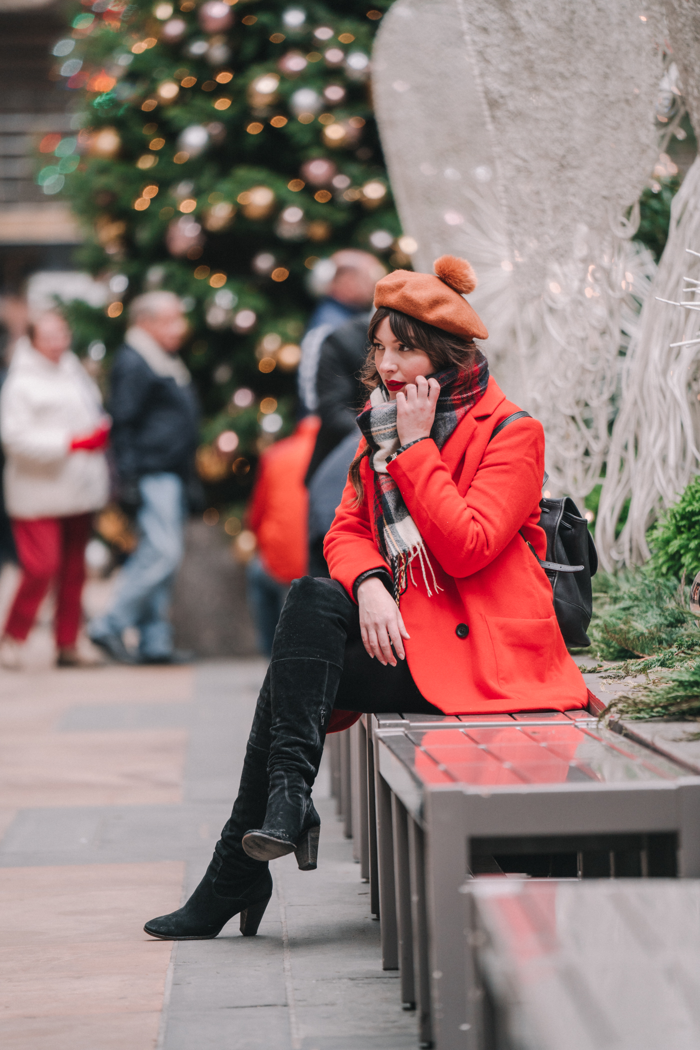 woman sitting in the mall and wearing red moto jacket and sharing it's beginning to look a lot like Christmas