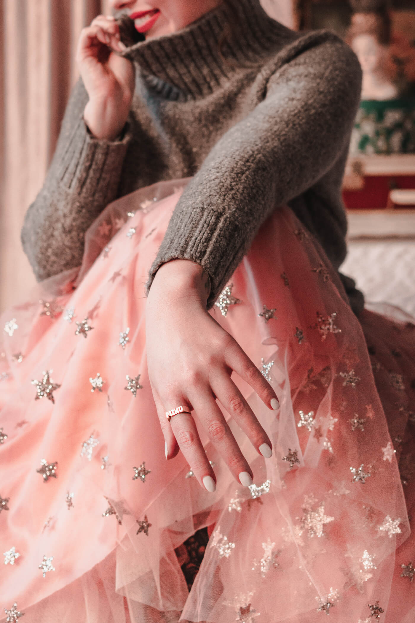 woman wearing grey sweater glitter skirt in a blush 