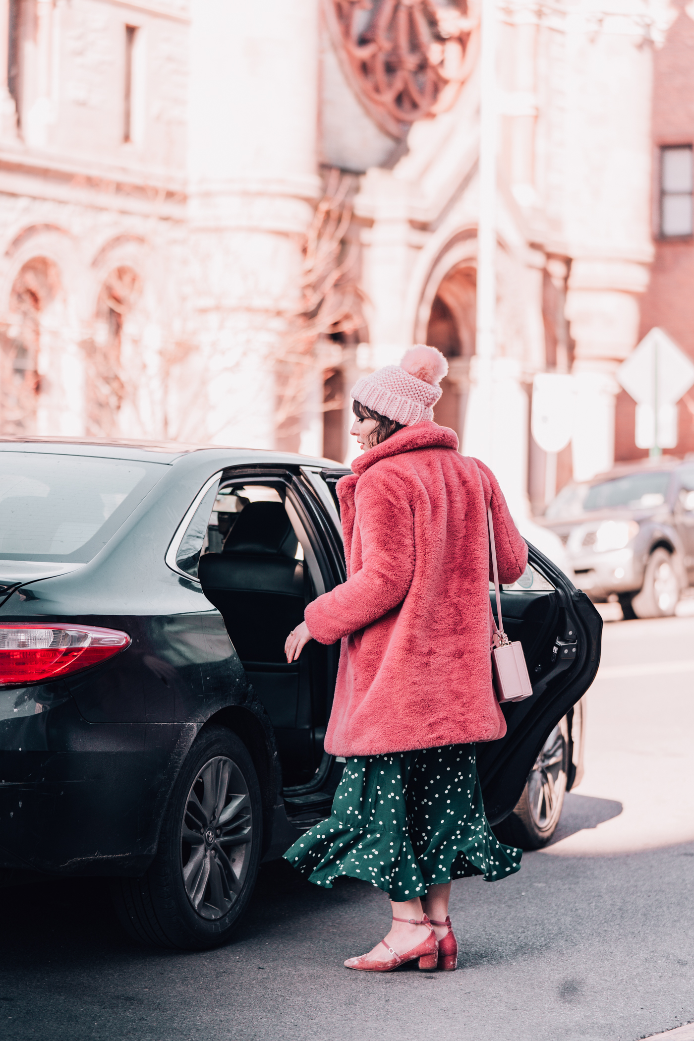 woman getting into a black car 