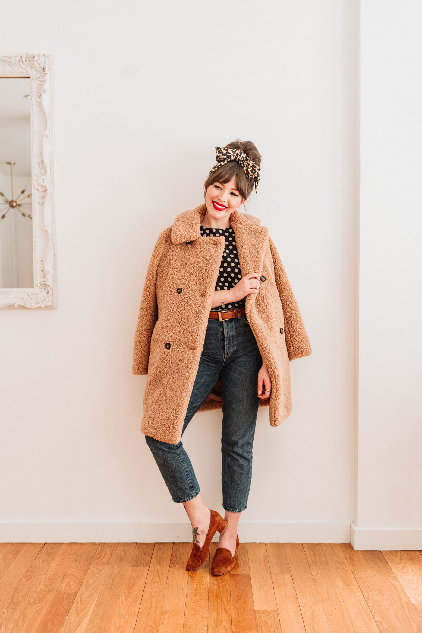 woman wearing polka dot top and jeans with teddy coat