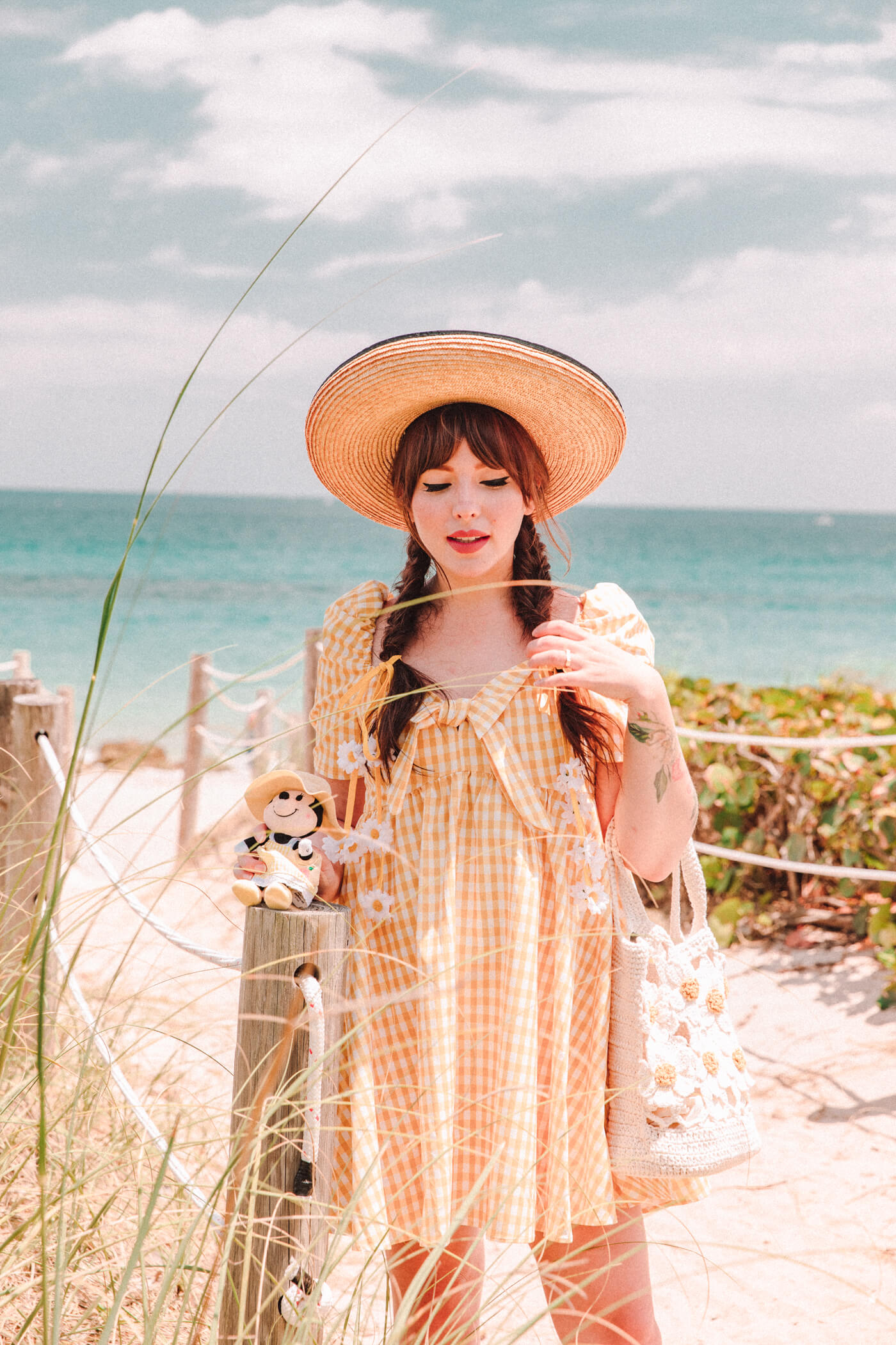 woman at the beach wearing yellow dress and a hat for nuiMOs Outfits