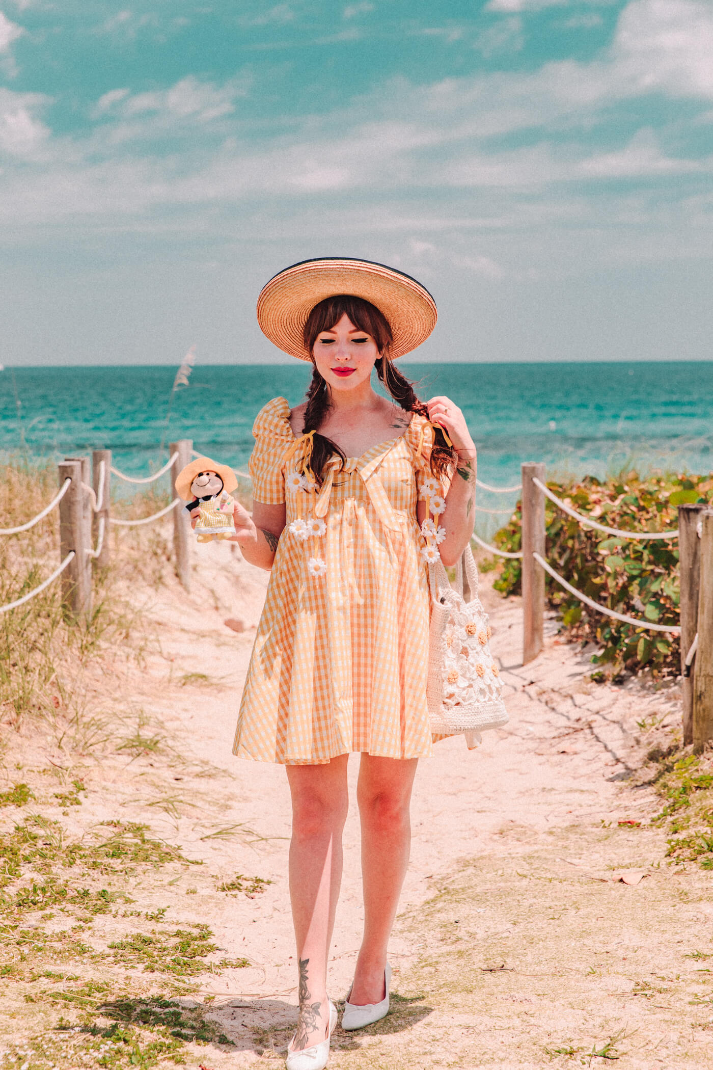 woman at the beach wearing white flats, yellow dress, and a hat for nuiMOs Outfits