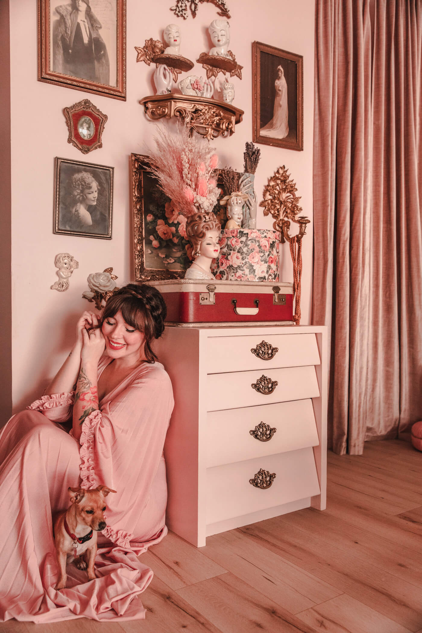 woman sitting beside a dresser with figurines on top