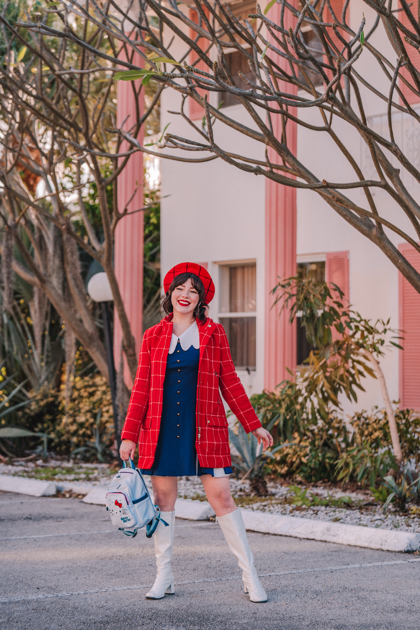 woman in Kipling x Hello Kitty backpack, vintage dress, old J.Crew coat, handmade beret, white gogo boots.