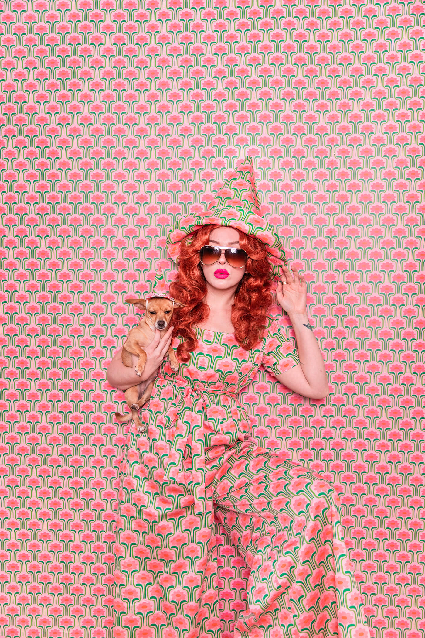 Evelyn Bourdon wearing a handmade dress and matching witch hat made out of Spoonflower fabric, in front of matching wallpaper in the same print.