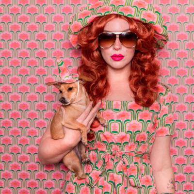 Evelyn Bourdon wearing a handmade dress and matching witch hat made out of Spoonflower fabric, in front of matching wallpaper in the same print.