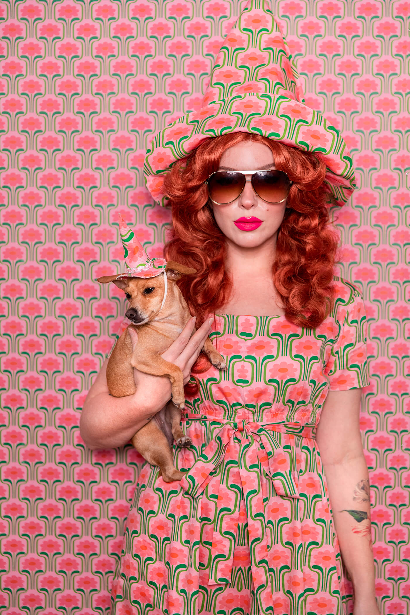 Evelyn Bourdon wearing a handmade dress and matching witch hat made out of Spoonflower fabric, in front of matching wallpaper in the same print.