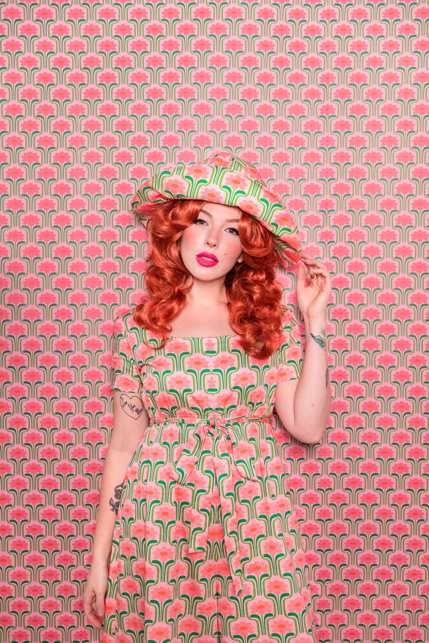 Evelyn Bourdon wearing a handmade dress and matching witch hat made out of Spoonflower fabric, in front of matching wallpaper in the same print.