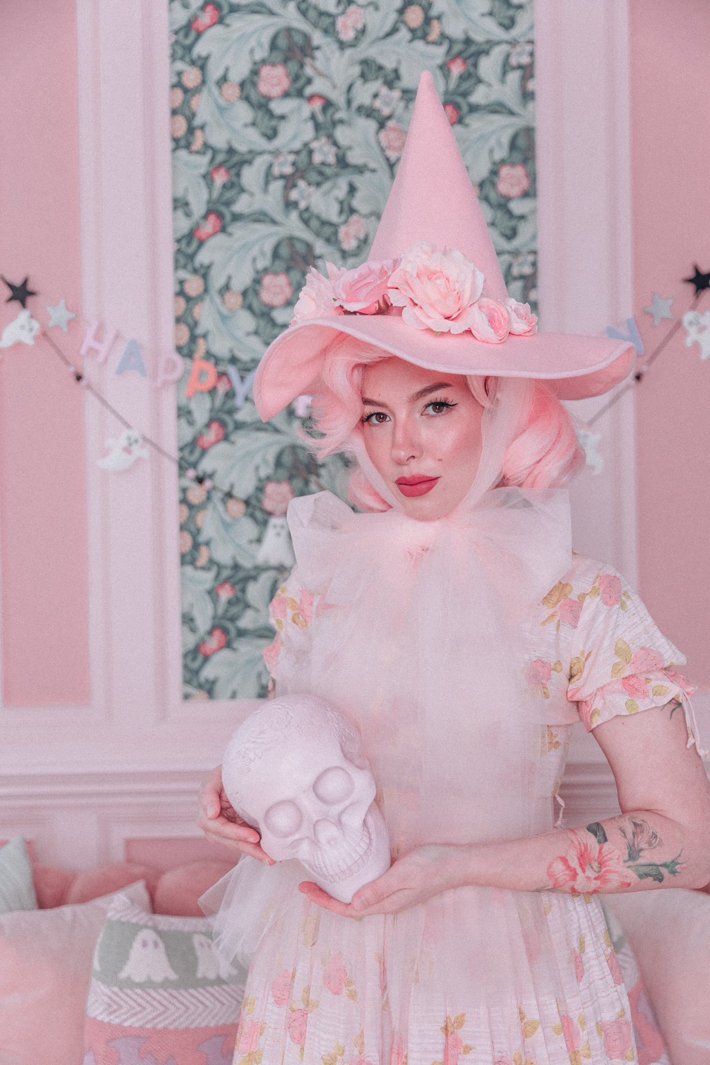 Woman wearing a pink witch hat with flowers and tulle ties